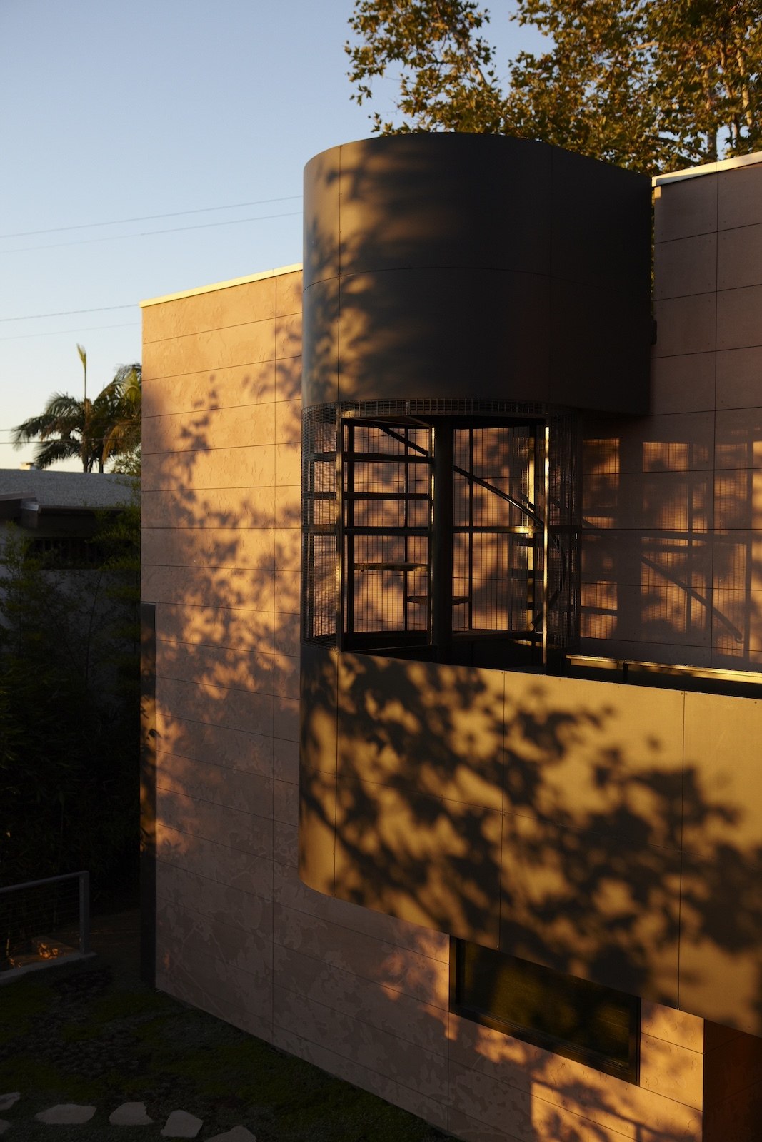 Tree shadows cover the outdoor spiral staircase